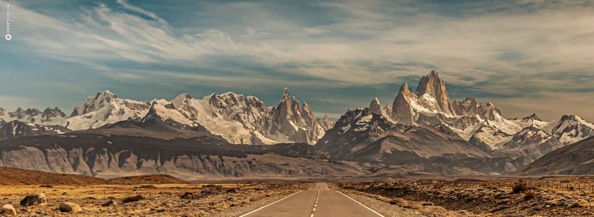 Monte Fitz Roy y Cerro Torre vistos desde El Chaltén en un día despejado, con cielo azul y la aguja de granito sin nubes