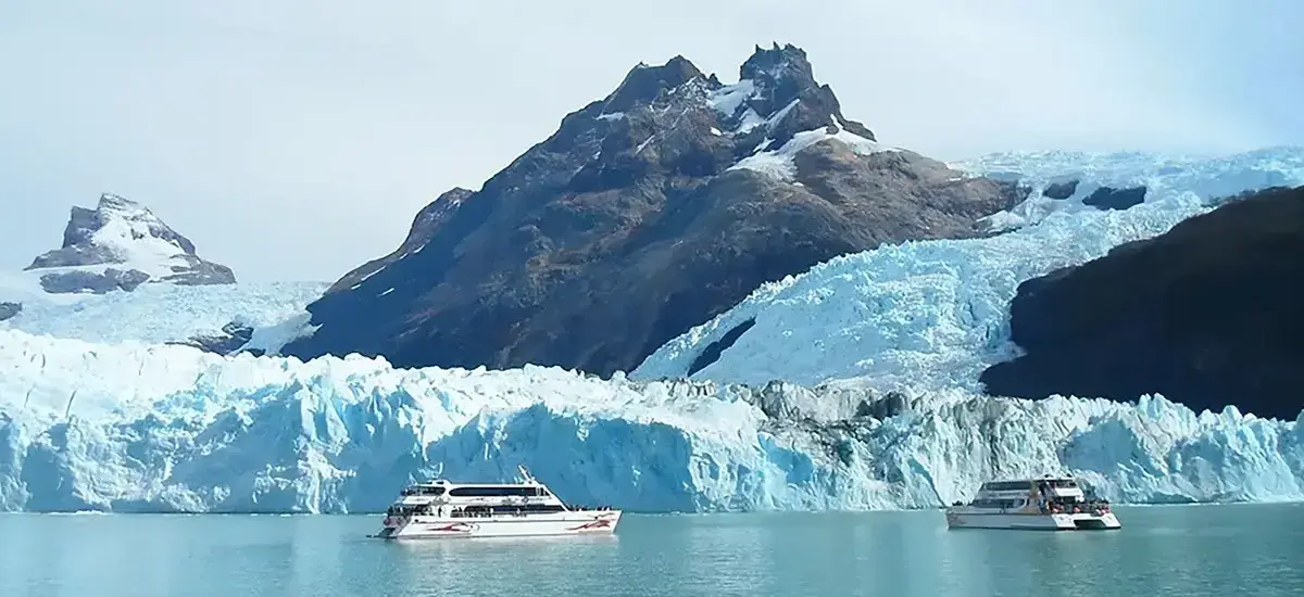 Boat sailing among blue icebergs in front of the Upsala Glacier on the North Arm of Lake Argentino